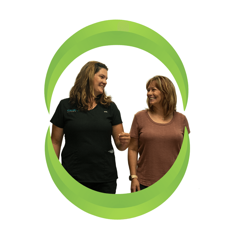 patient and staff member walking together and smiling brightly after patient's dental procedure