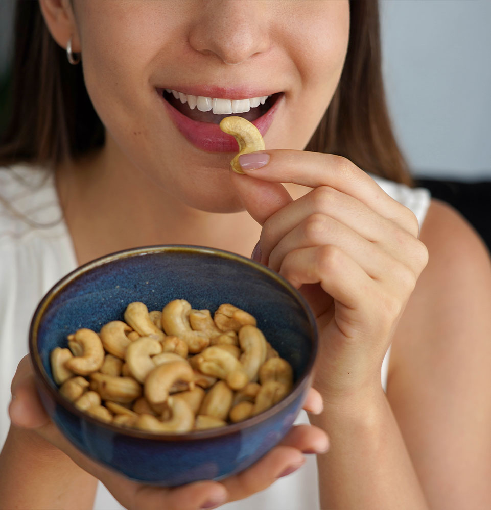 young women snacking and chewing into some cashews