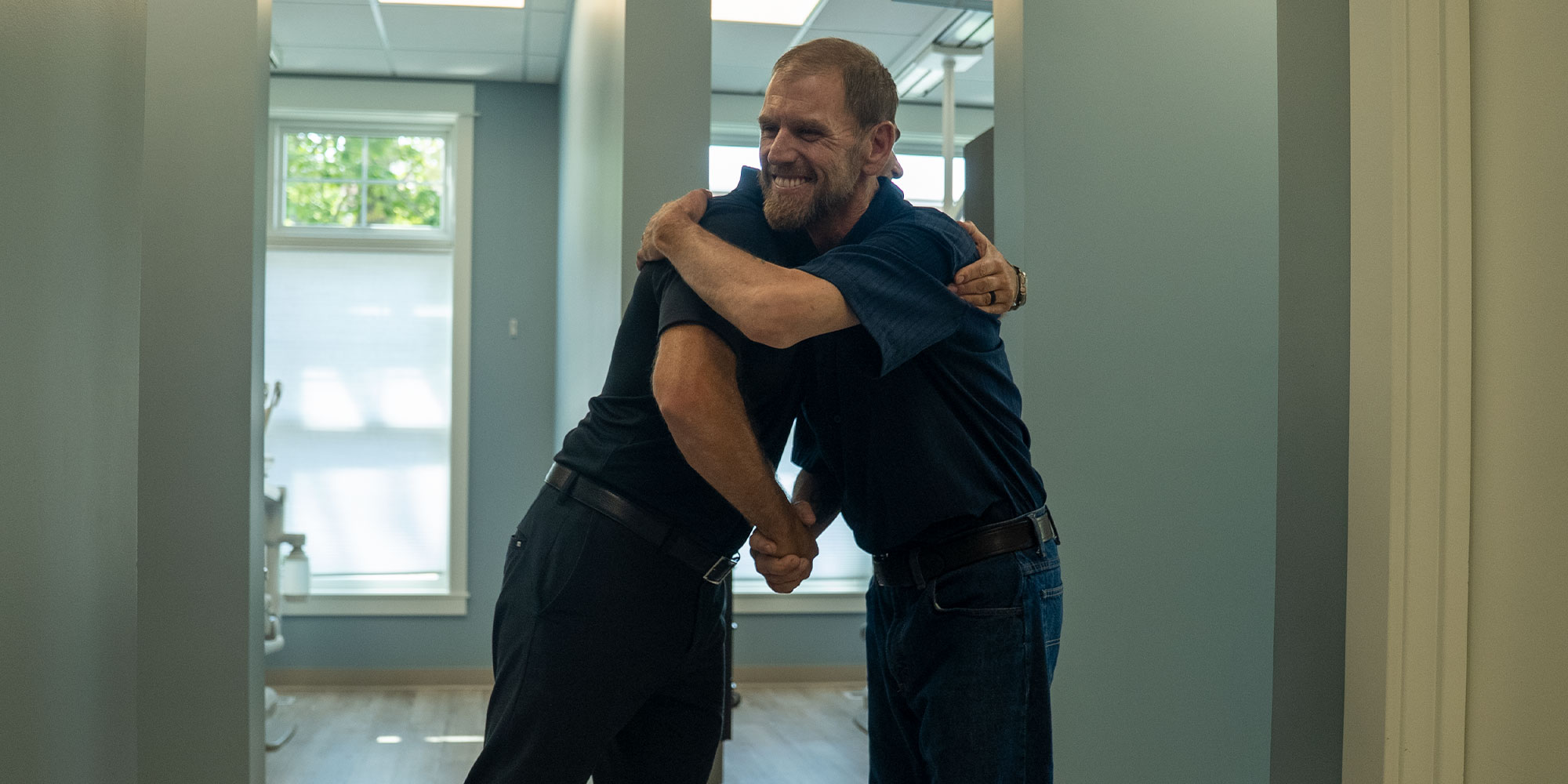 patient and doctor hugging after patient's dental procedure