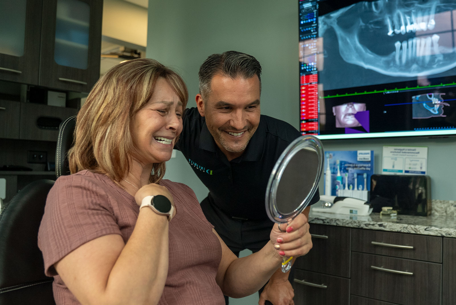 patient and doctor smiling together after patient's dental implant procedure