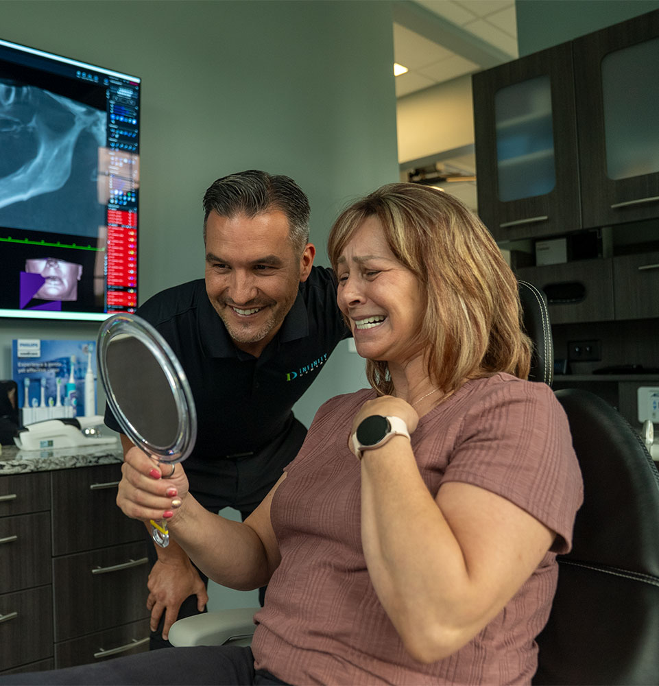 Patient smiling brightly after their dental procedure with doctor within the dental center