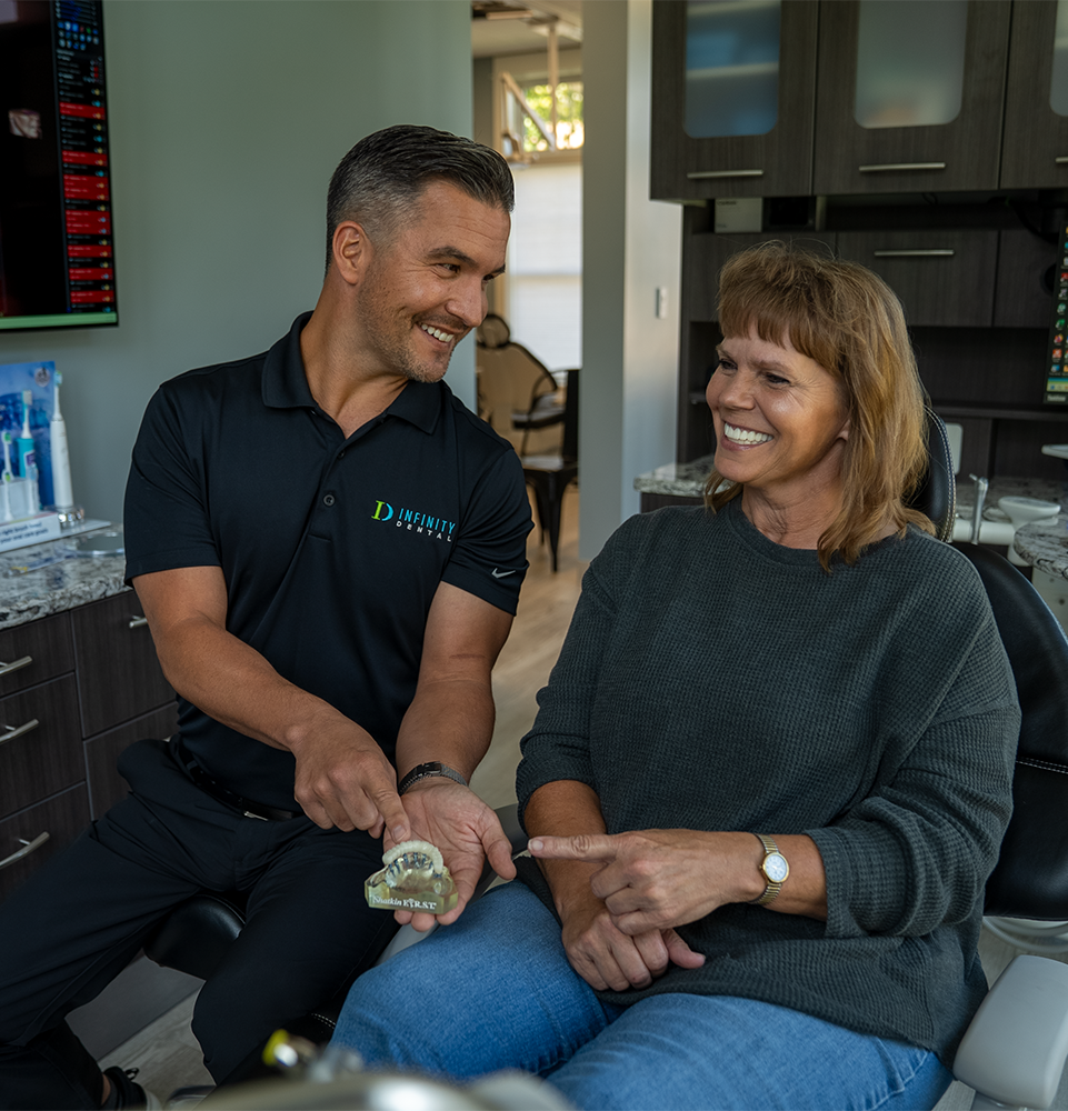 doctor showing patient dental implant model