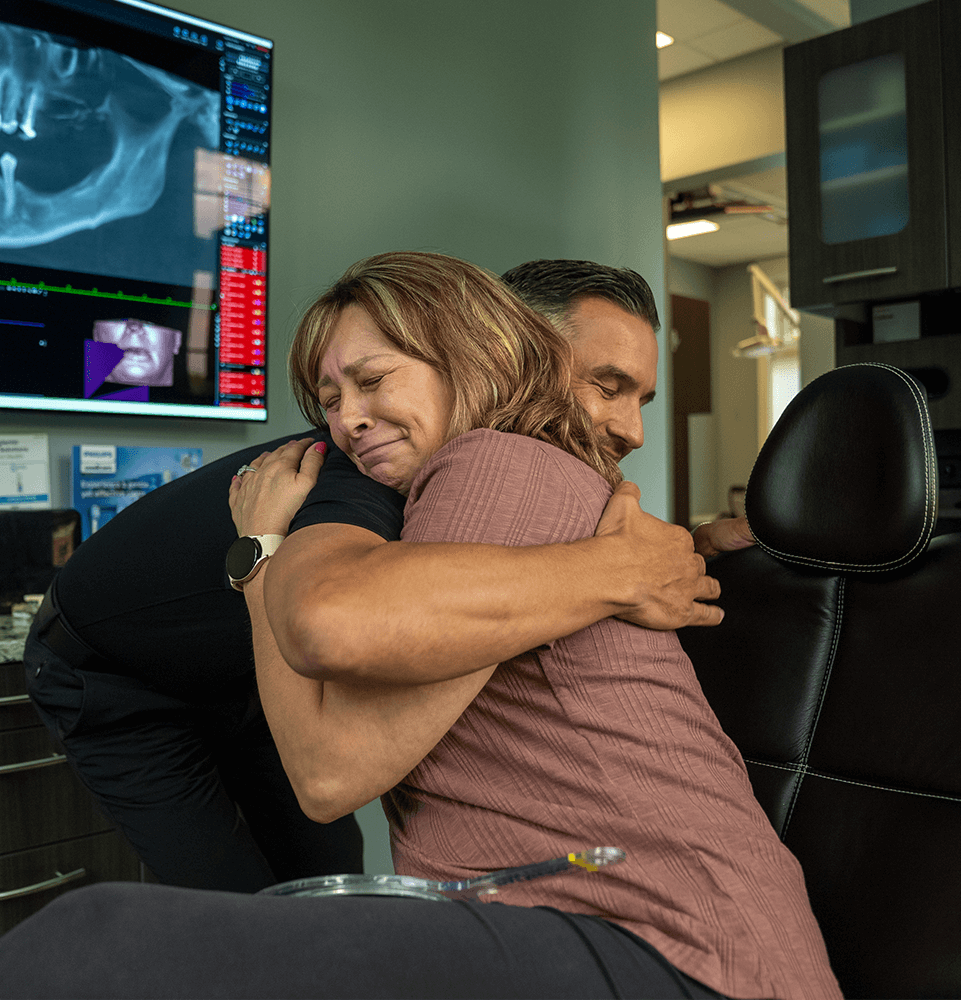 patient and doctor hugging each other warmly after patient's dental procedure